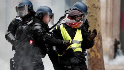 French officers apprehend a protester during a "yellow vest" demonstration in Paris, 8 December