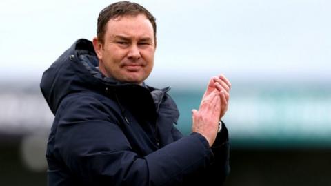 Morecambe boss Derek Adams applauds the fans