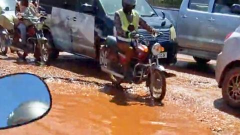 Traffic by a pothole in Kampala, Uganda