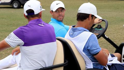 (l-r) Rickie Fowler, Rory McIlroy and his caddie Harry Diamond in a golf buggy