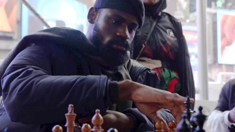 In this screen grab taken from video, Tunde Onakoya, 29- years old, a Nigerian chess champion and child education advocate, play a chess game in Times Square, New York, Thursday, April, 18, 2024. A Nigerian chess player and child education advocate is attempting to play chess nonstop for 58 hours in New York City's Times Square to break the global record for the longest chess marathon and raise $1m for the education of children across Africa
