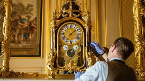 Horological conservator Fjodor van den Broek adjusts a clock