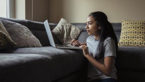 girl working on laptop at home