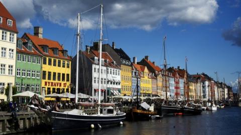 A canal in Copenhagen lined with attractive multi-coloured buildings