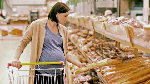 Woman choosing bread in supermarket