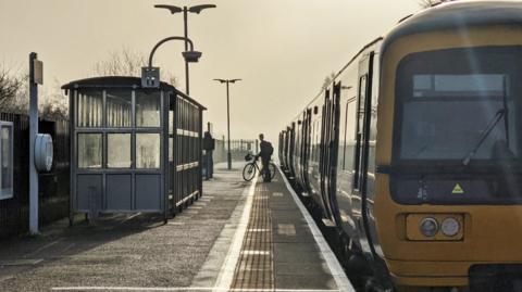 A train at Severn Bridge. Someone with a bike is on the platform.