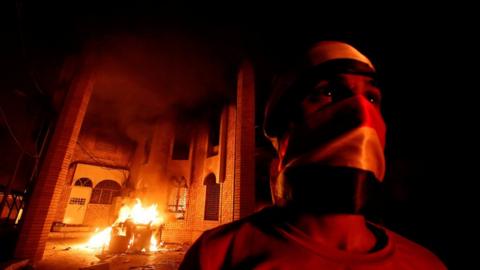 Iraqi protesters are seen near the burnt Iranian Consulate in Basra, 7 September 2018