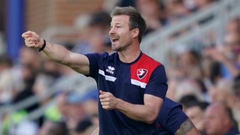 Cheltenham head coach Wade Elliott gives instructions to his team from the touchline in their game away to Portsmouth