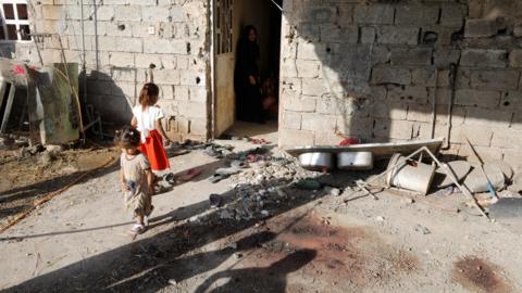 Children are seen near a house damaged by a rocket attack in Abu Ghraib, Baghdad, Iraq (29 September 2020)