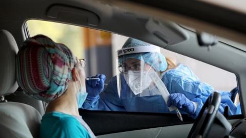 A member of the Shaare Zedek Hospital Medical team issues a coronavirus examination outside the biological emergency room that treats coronavirus patients at Shaare Zedek Hospital in Jerusalem, Israel, 11 September 2020.