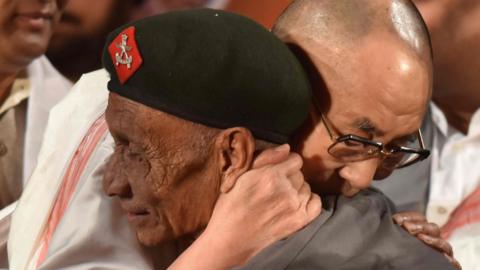 In this photograph taken on 2 April 2017, Tibetan spiritual leader the Dalai Lama (L) hugs retired Assam Rifles personnel Naren Chandra Das
