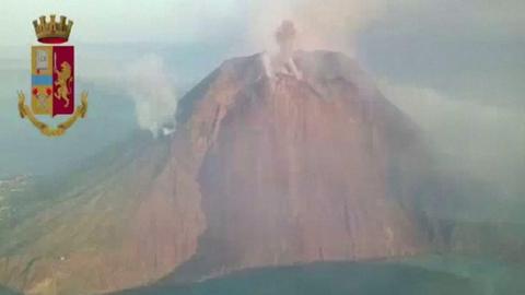 The volcano spews ash amid a blue sea