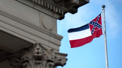 The Mississippi state flag flies outside the State Capitol building in Jackson, Mississippi, 28 June 2020
