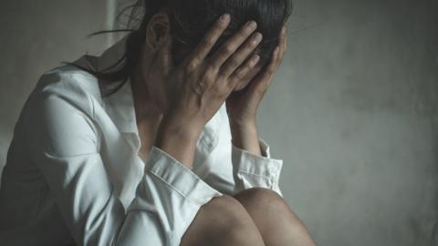 Stock image of a woman with her head in her hands