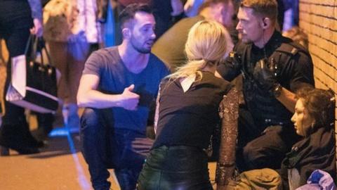 Police and other emergency services are seen helping the injured near the Manchester Arena after an explosion.