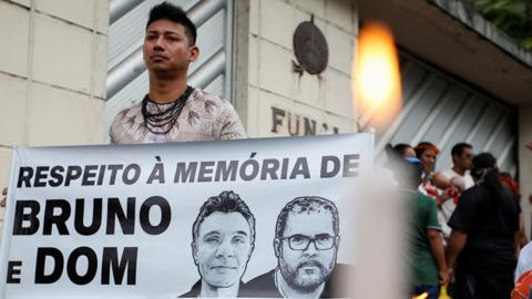 A demonstrator holds a banner reading "In respect of the memory of Bruno and Dom" during a protest following the disappearance of British journalist Dom Phillips and indigenous expert Bruno Pereira