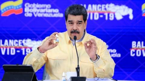 Nicolás Maduro holds up his unfounded herbal remedy "cure"