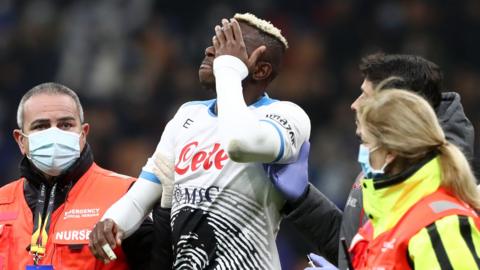 Napoli and Nigeria striker Victor Osimhen being led off the pitch by medics