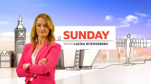Laura Kuenssberg stands in front of a branded backdrop with a banner for the show titled Sunday with Laura Kuenssberg.