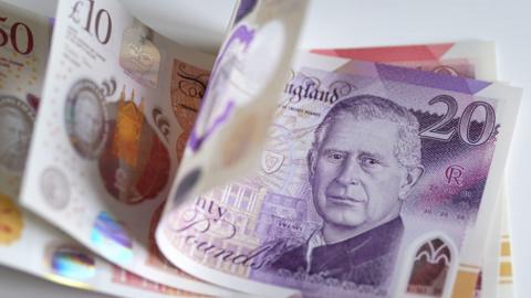 Image of a £20 note together with a £10 note and £50 sitting on top of each other. The £20 note has a picture of King Charles on it