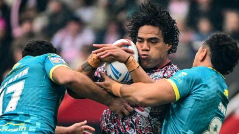 Leigh's Joe Ofahengaue is tackled by Sauaso Sue of Hull KR