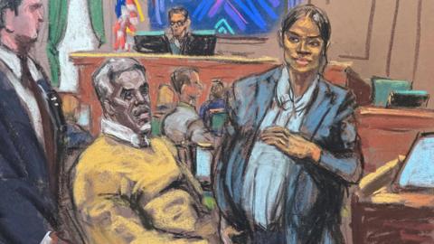 Sean "Diddy" Combs watches as Casandra "Cassie" Ventura leaves for a break in her testimony during Combs' sex trafficking trial