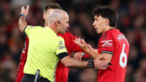 Paul Tierney speaks to Lisandro Martinez after issuing the Manchester United centre-back with a red card