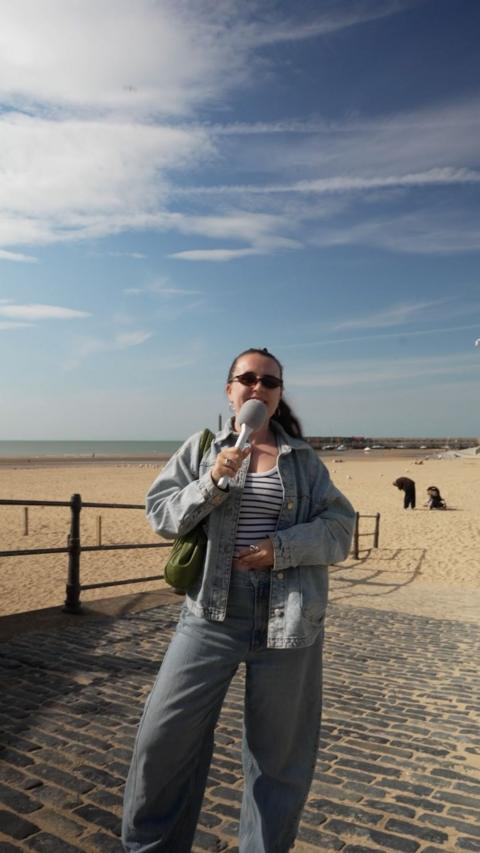 Harriet Fisher stood on the edge of the beach with a microphone
