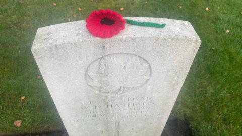 A single poppy lying on the top of a war grave at the Commonwealth War Graves Cemetery in Runnymede