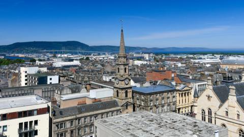 A view across Inverness city centre towards the Kessock Bridge and the Black Isle on a sunny day.