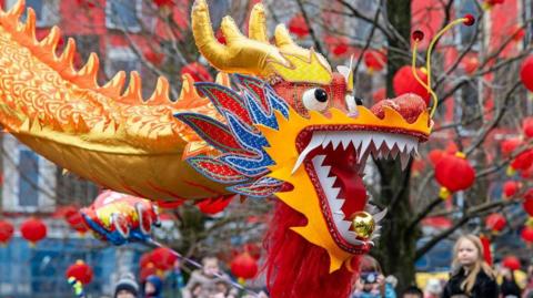 A gold, orange and red Chinese dragon used in a performance to celebrate Chinese New Year at Blackstock Market in Liverpool.