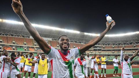 Adamo Nagalo celebrates with his arms outstretched above his head after Burkina Faso qualify for the 2025 Africa Cup of Nations