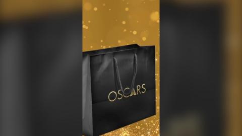 A black gift bag with the word 'Oscars' on the side
