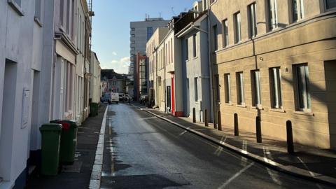 A street in St Helier with cars on the road in the distance.