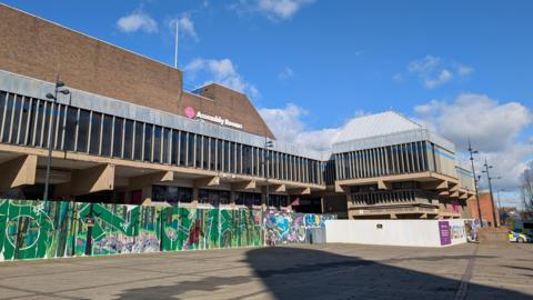 The Derby Assembly Rooms building surrounded by walls with graffiti 