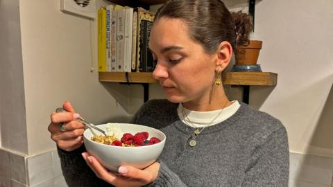 Laura eats her breakfast