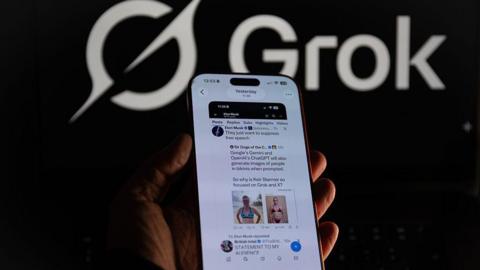 An iPhone screen displays Elon Musk's repost on his social media platform X regarding criticism from British Prime Minister Kier Starmer about his AI tool Grok