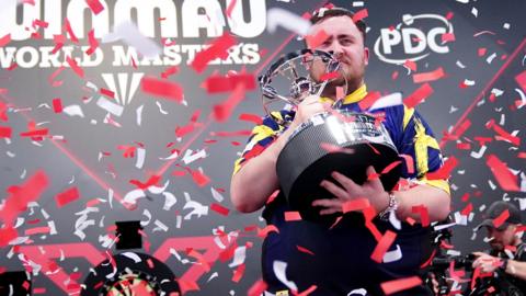 Luke Littler celebrates winning the World Masters title
