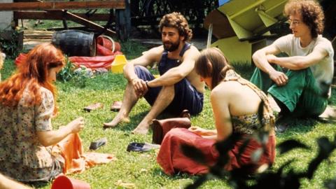 People sitting together with children talking at home in an urban Camberwell communal garden in the 1976 heatwave in South London