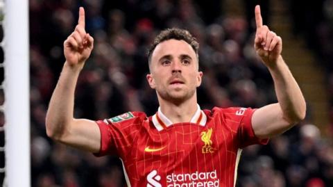 Jota points his two index fingers towards the sky as he celebrates scoring a goal