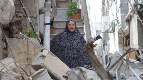 A Palestinian woman inspects damage to her house after an Israeli operation in Nur Shams refugee camp, in the occupied West Bank (30 August 2024)