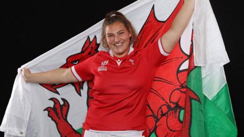 Gwenllian Pyrs posing with the welsh flag in her kit