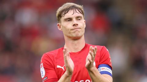 Barnsley captain and goalscorer Luca Connell claps. 