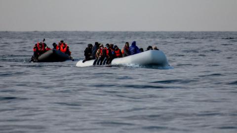 Two inflatable dinghies carrying migrants make their way towards England in the English Channe