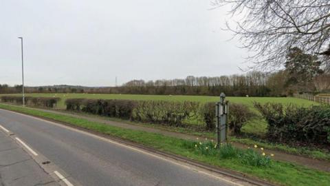 Streetview image of a grazing field surrounded by low hedges