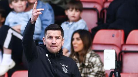 Crewe Alexandra boss Lee Bell points instructions to his players during a match