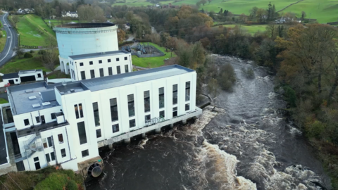 An impressive art deco hydro building in white with long thin windows on the banks of a river