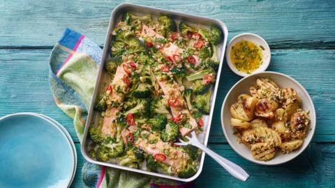steam roasted salmon served in an oven dish with a bowl of potatoes on the side