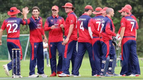 Jersey players celebrate taking a wicket