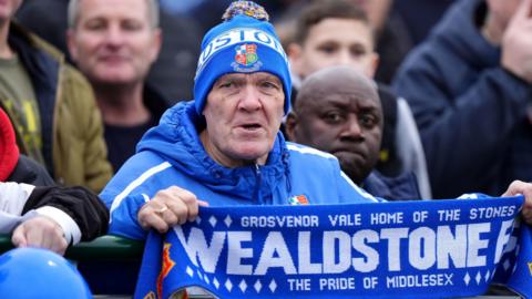 A Wealdstone fan wearing blue kit in the stands during the Emirates FA Cup second round match at the Grosvenor Vale, Ruislip.